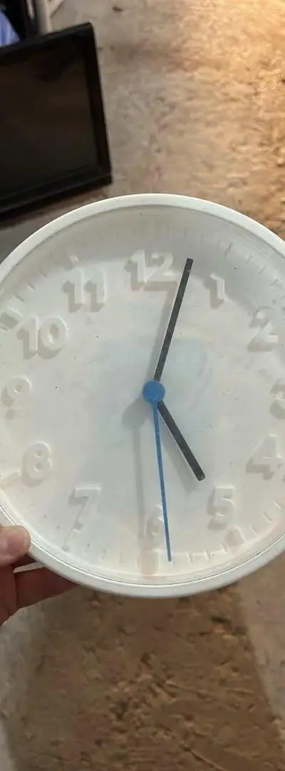 Horloge murale blanche en bon état.