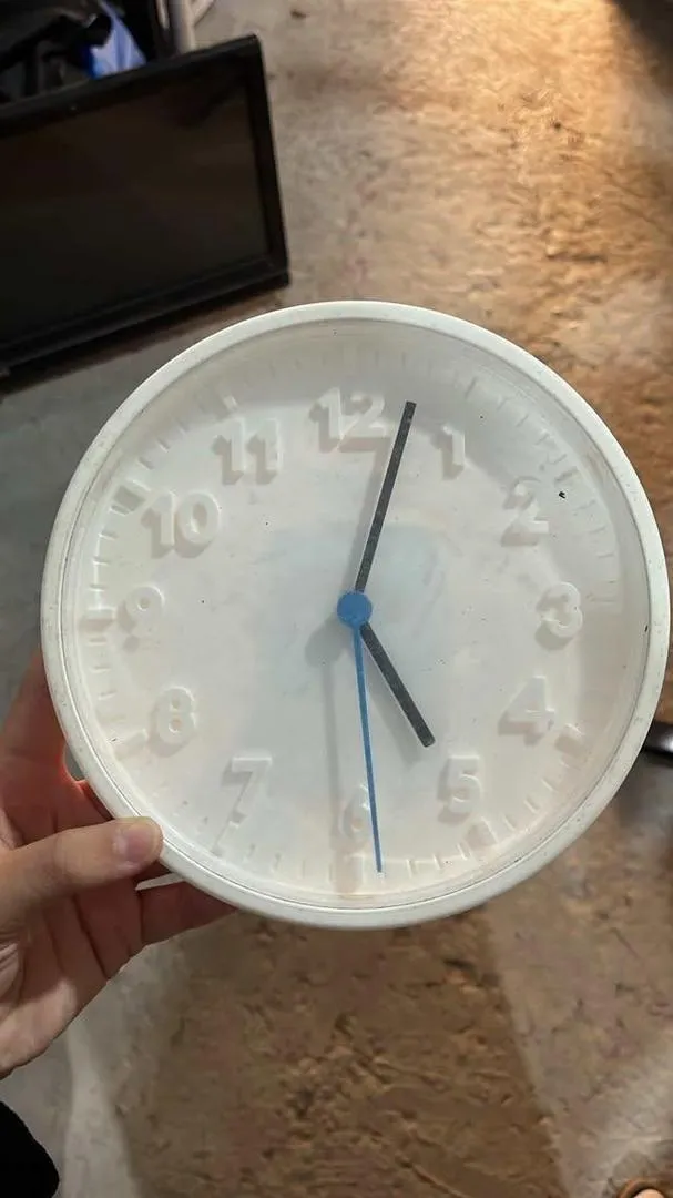 Horloge murale blanche en bon état.