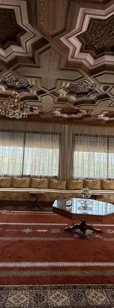 Salon marocain avec tapis, tables et lustres