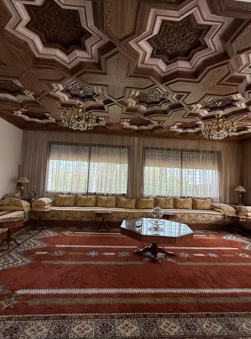 Salon marocain avec tapis, tables et lustres