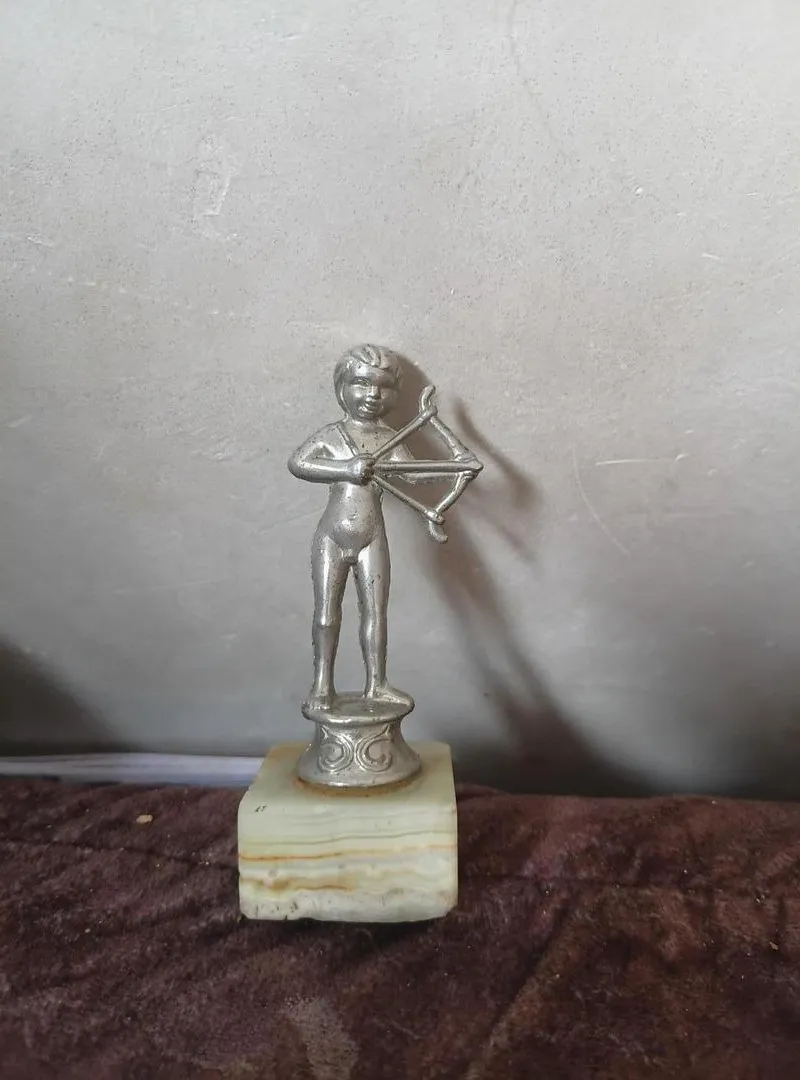 Très ancienne statue en métal sur marbre